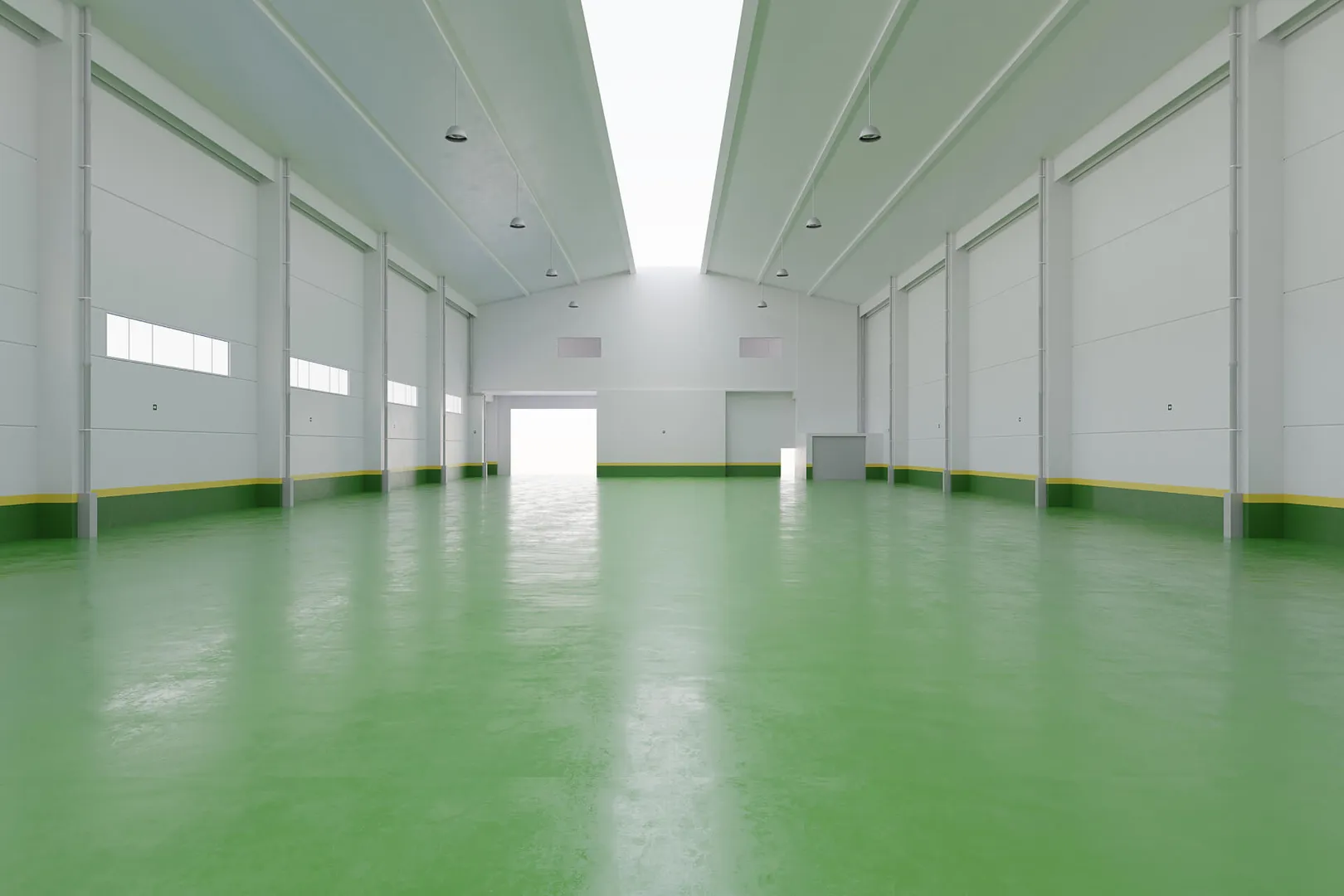 Empty warehouse with green floor and high ceiling.