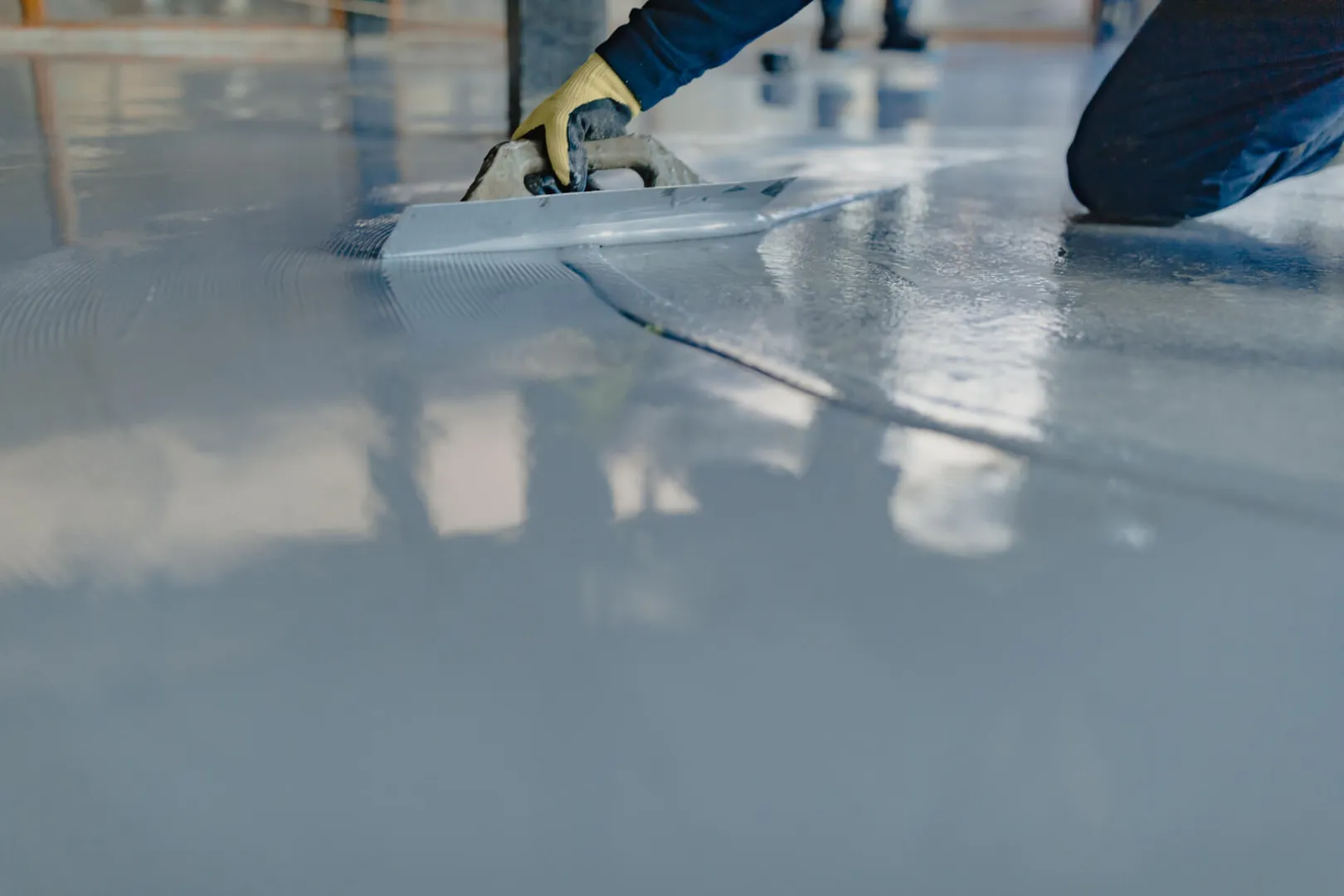 Worker smoothing concrete floor